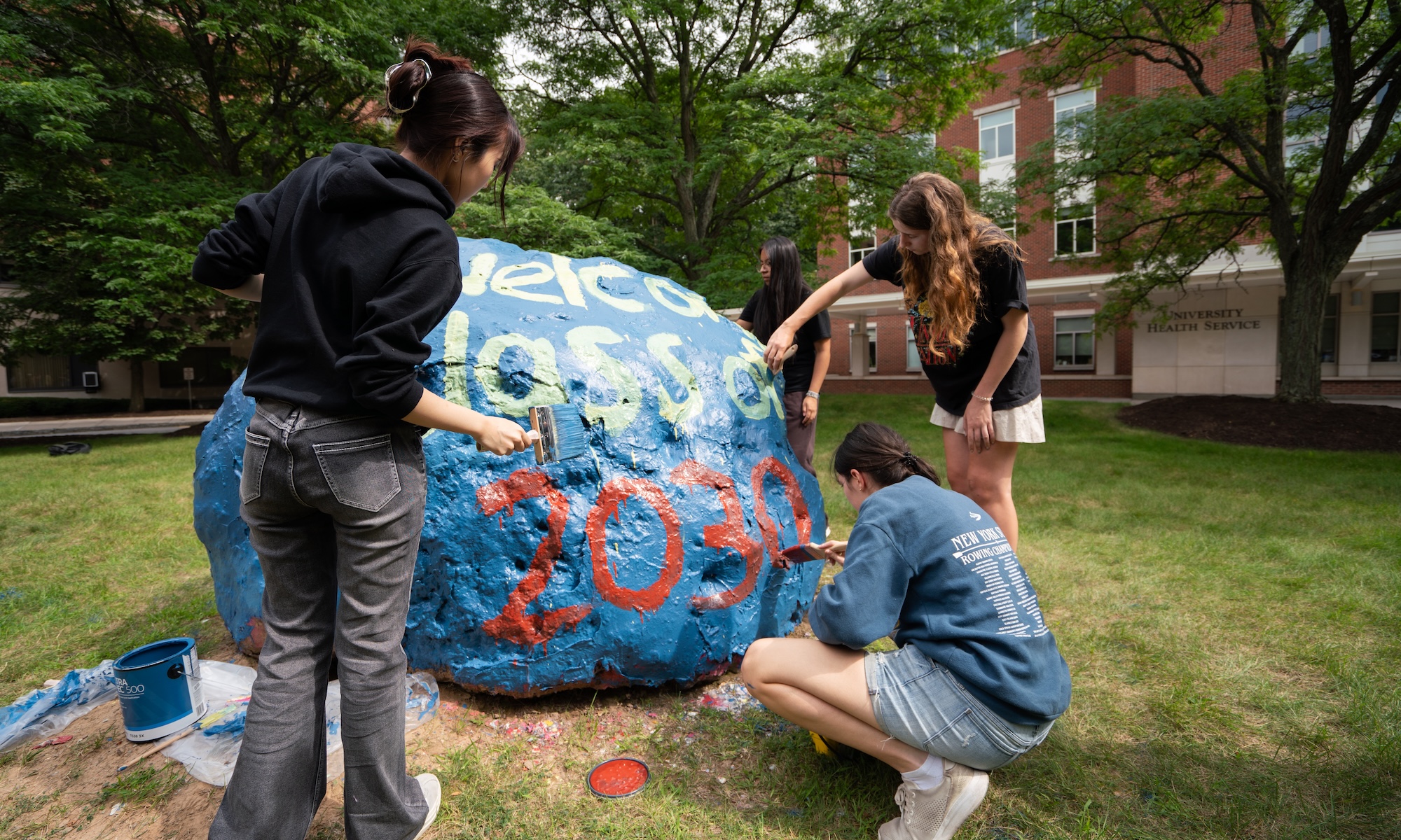 University of Rochester D’Lions student orientation leaders paint the Class Rock.