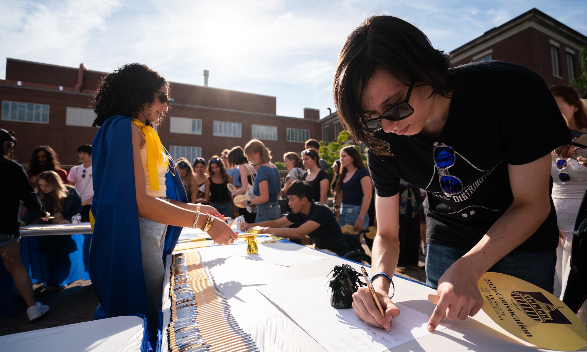 Students sign the class roll.