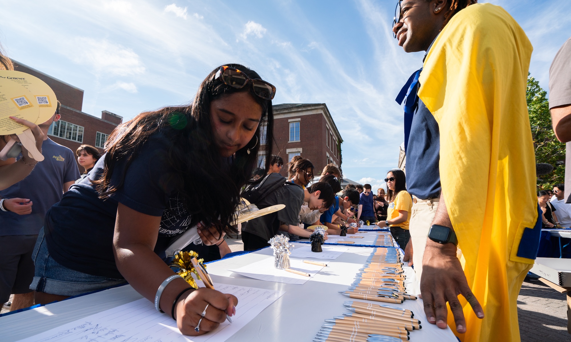 Students sign the class roll.