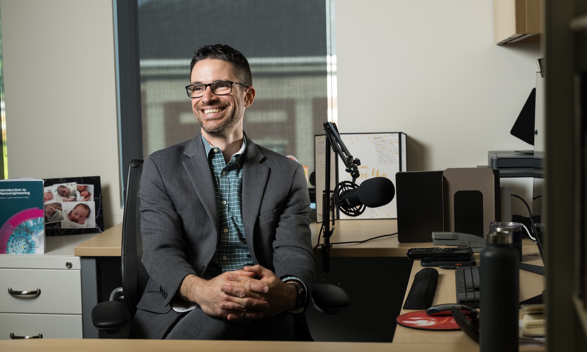 Darren Lipomi in his office, behind a podcast mic.