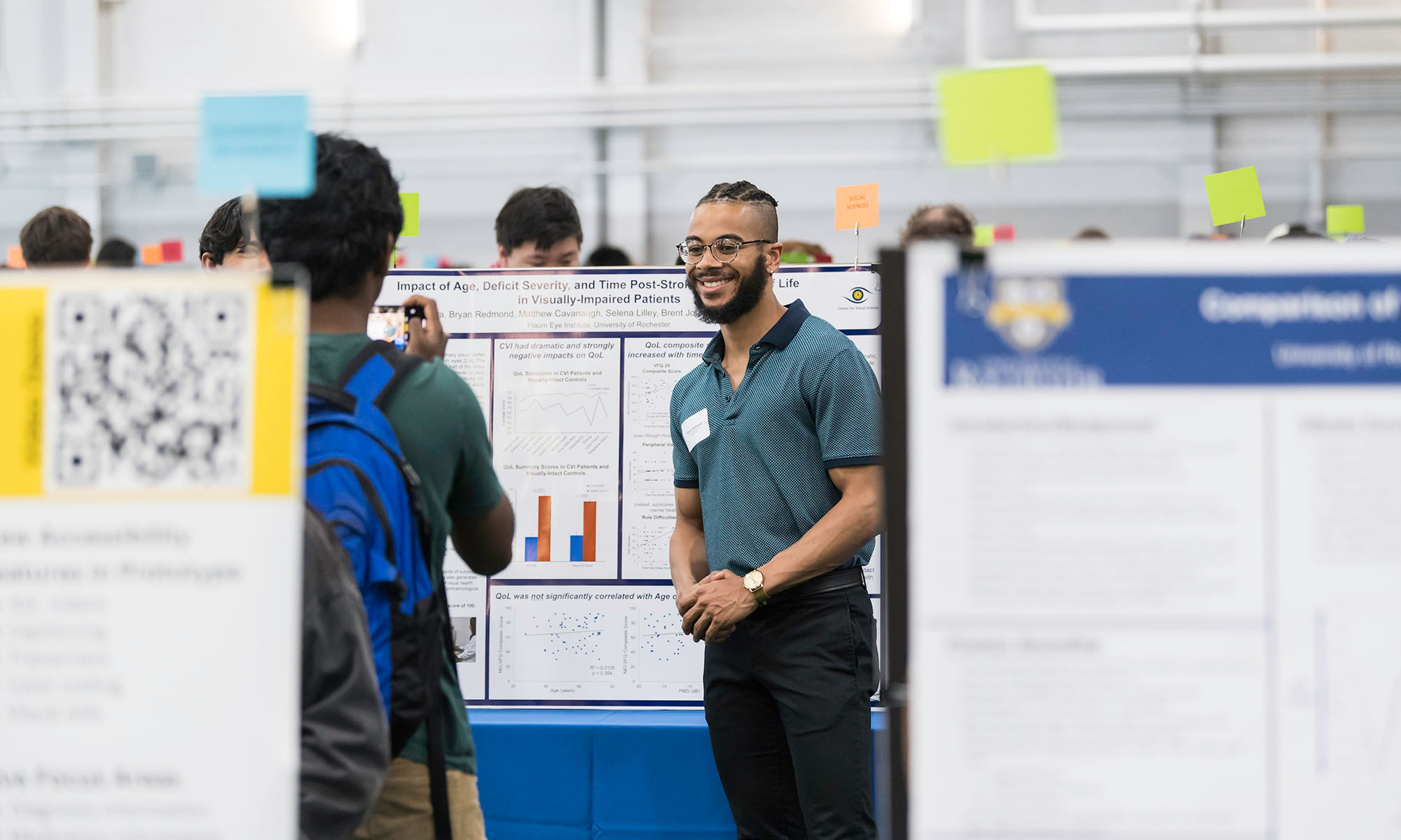 URochester student wearing business casual clothes to present his poster at the Undergraduate Research Expo.
