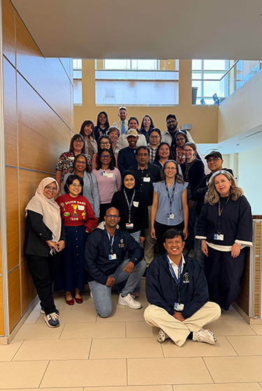 Incoming Warner School graduate students pose for a group photo on the stairs inside LeChase Hall.