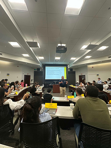 Simon MBA students in a classroom with a facilitator for orientation.