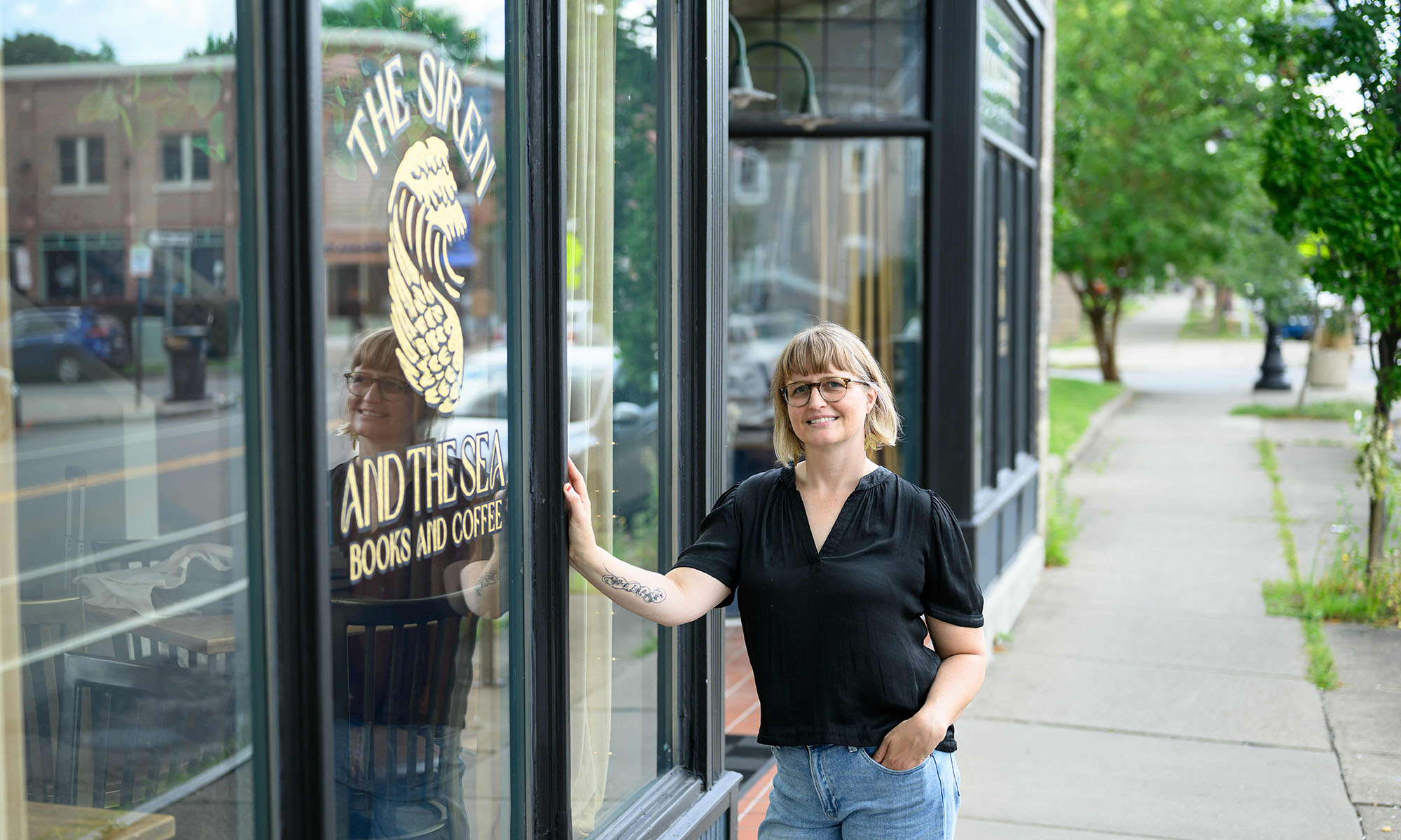 Jess Gale stands outside her store, The Siren and the Sea: Books and Coffee.