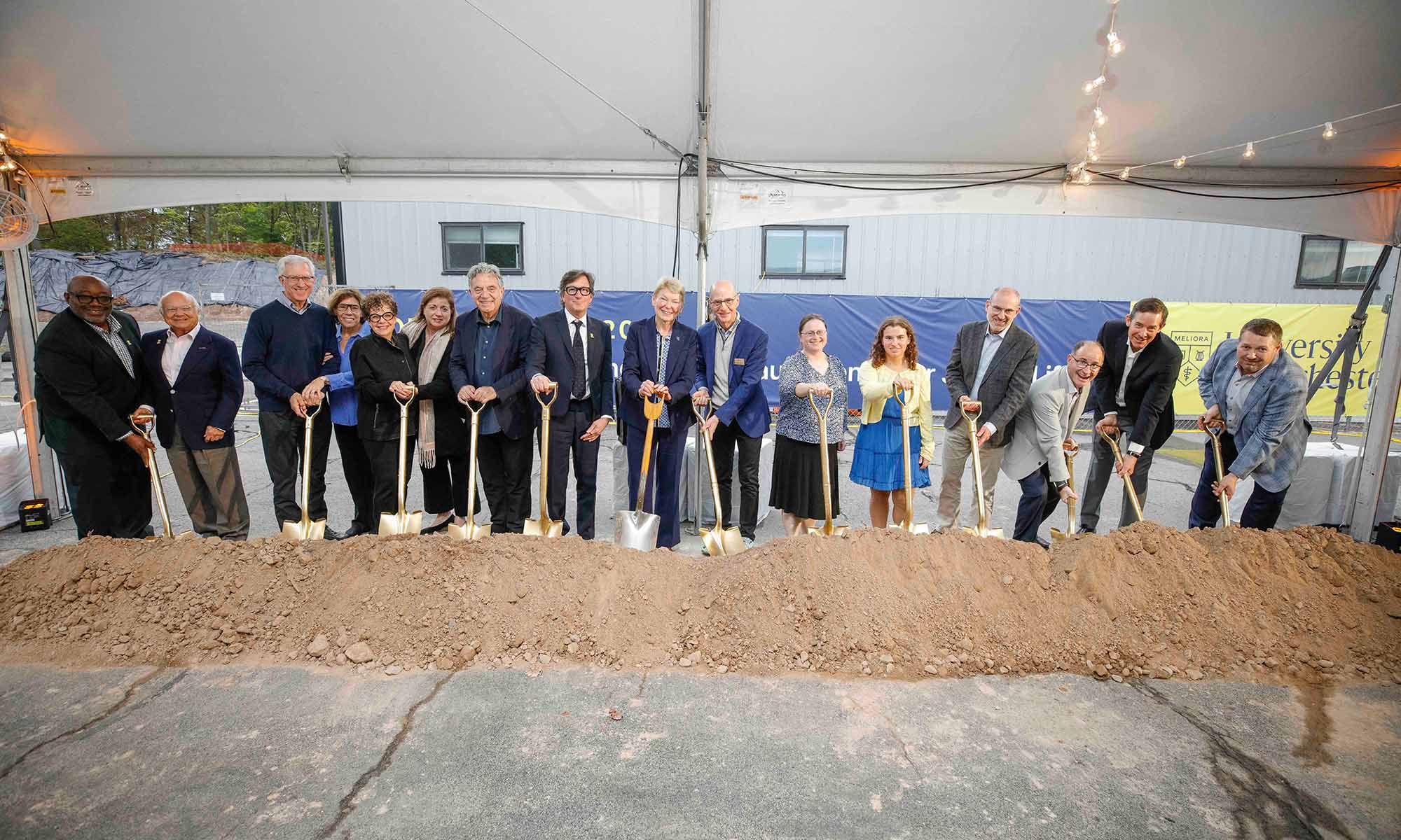 URochester president Sarah Mangelsdorf flanked by more than a dozen leaders, trustees, donors, and others at the ceremonial groundbreaking for the new Student Life Building and Greenbaum Center for Jewish Life.