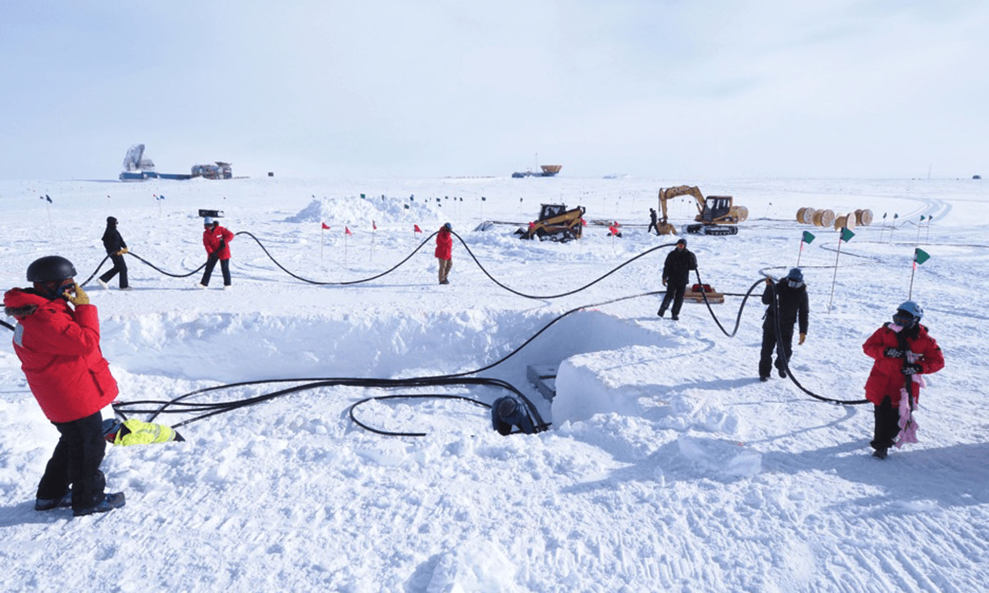 Group of people in parkas pulling a cable along as they work out on the ice.
