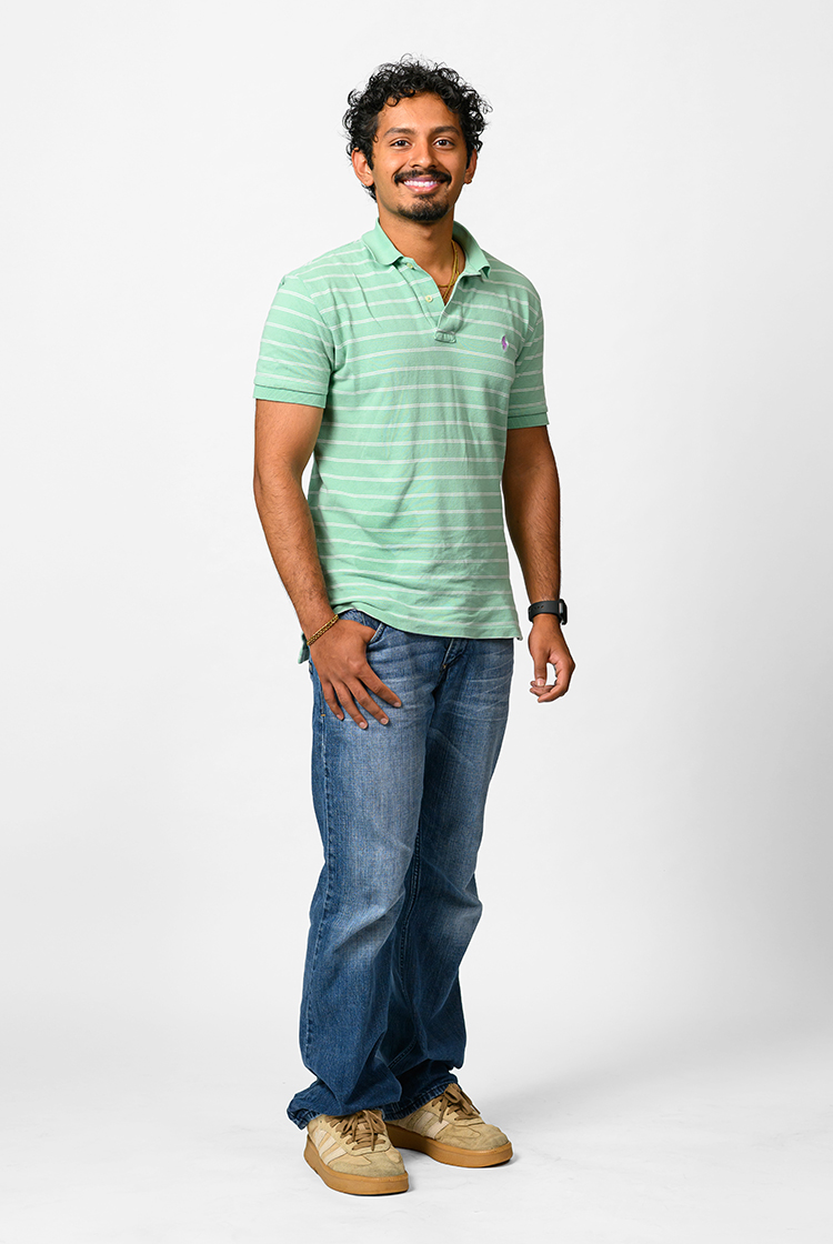 Jeffrey Jose in a short-sleeve, seafoam-green polo shirt with thin white stripes, jeans, and tan shoes.