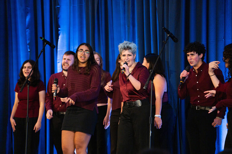 Members of a cappella group After Hours perform on stage.