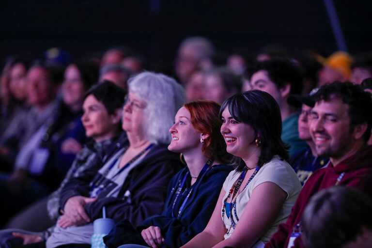 Audience members awash in purple light during Nick Offerman's Meliora Weekend 2026 set.