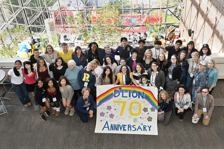Overhead group photo with people holding up a big sign that 