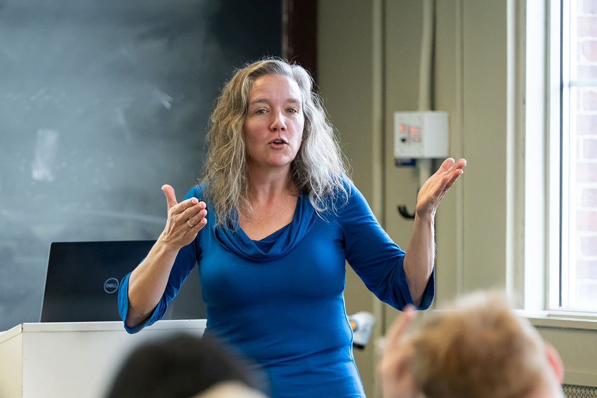 Anthropologist Kristin Doughty speaks to students in a classroom, gesturing with both hands.