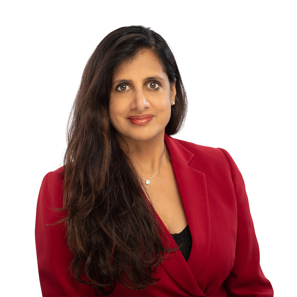 Square portrait of Sujatha Ramanujan in a red suit against a white background.