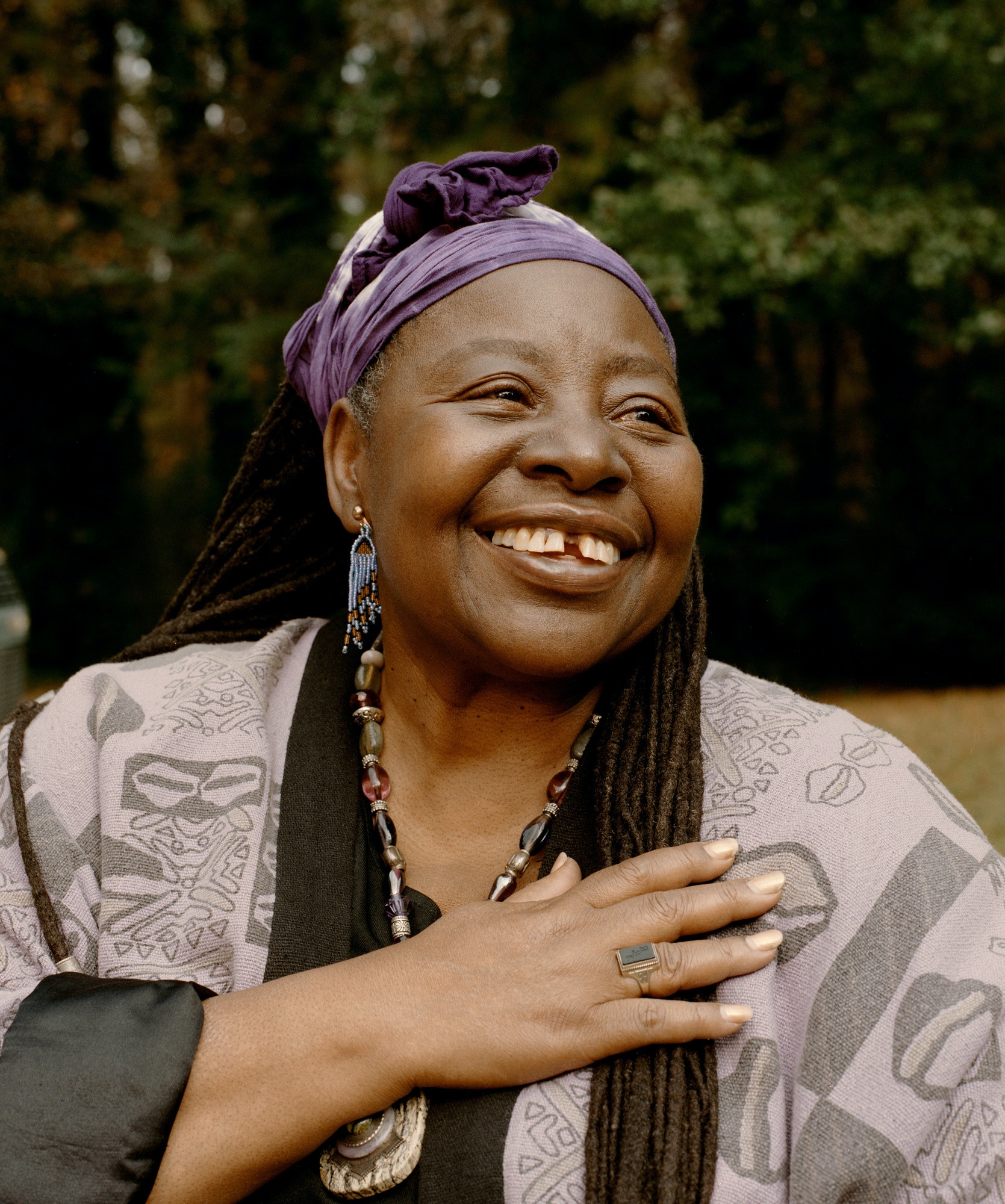 Loretta Ross smiles and holds hand to chest.