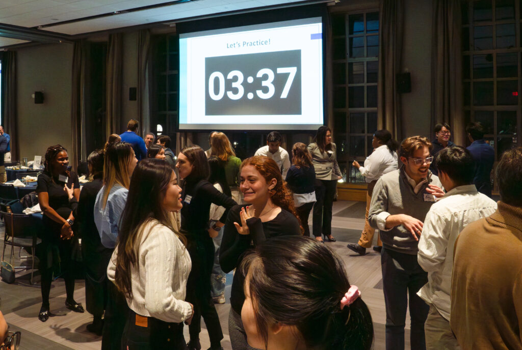 Students at a networking event, talking around the room and talking with peers