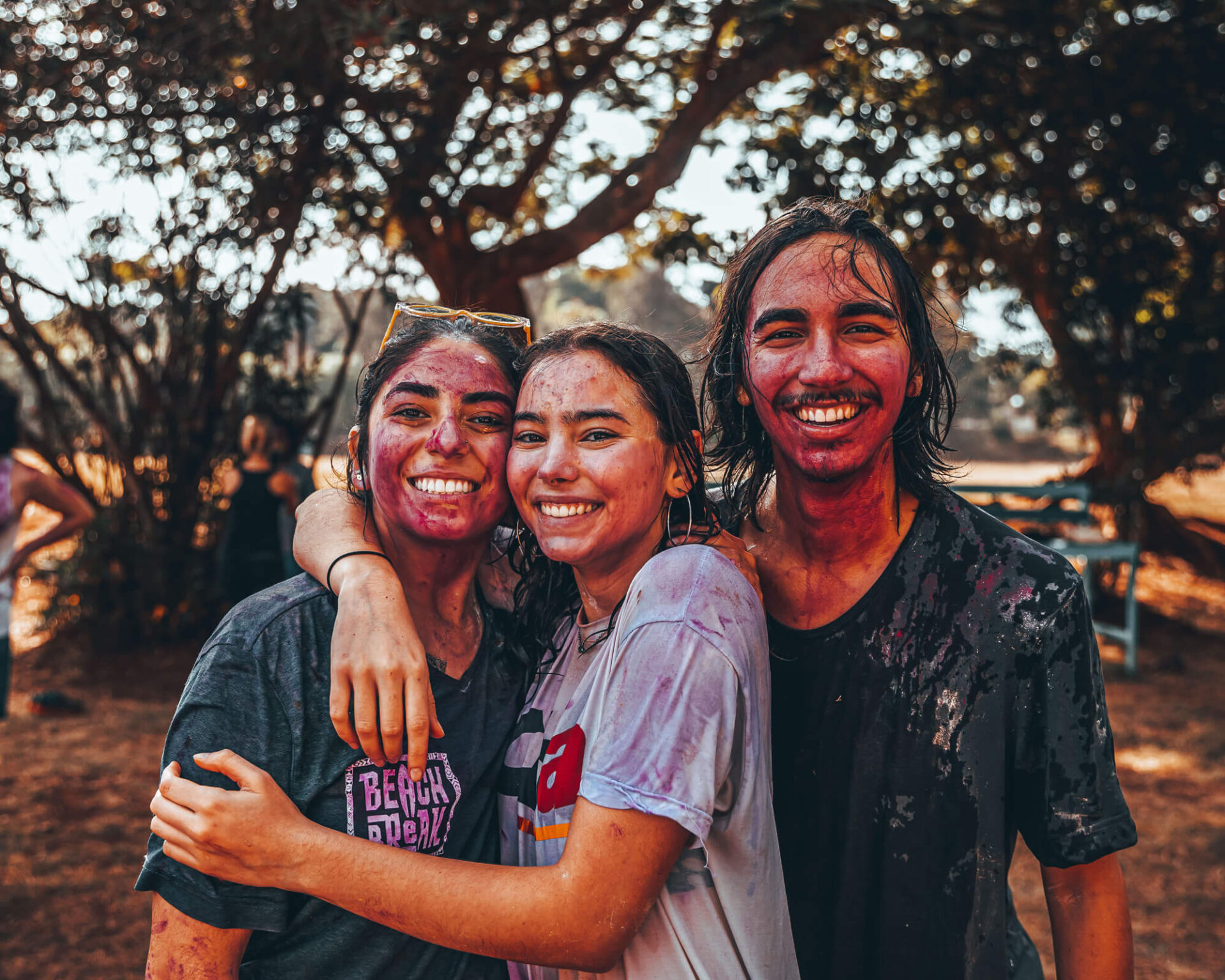 A photo of three students celebrating the Hindu festival of colors, each covered in body paint