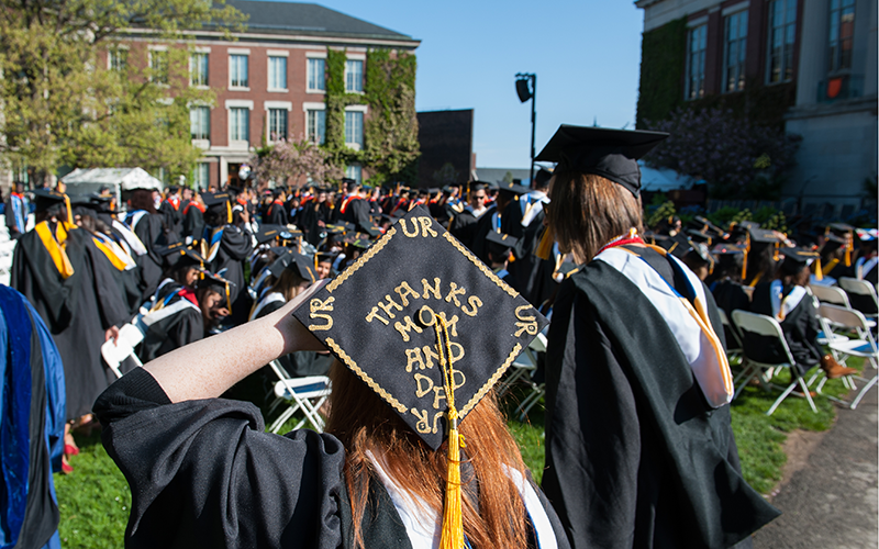 Photo of students with backpacks walking across Eastman Quad in front of Rush Rhees Library on River Campus