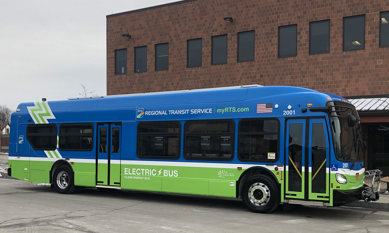 Blue and green RTS electric bus on city street