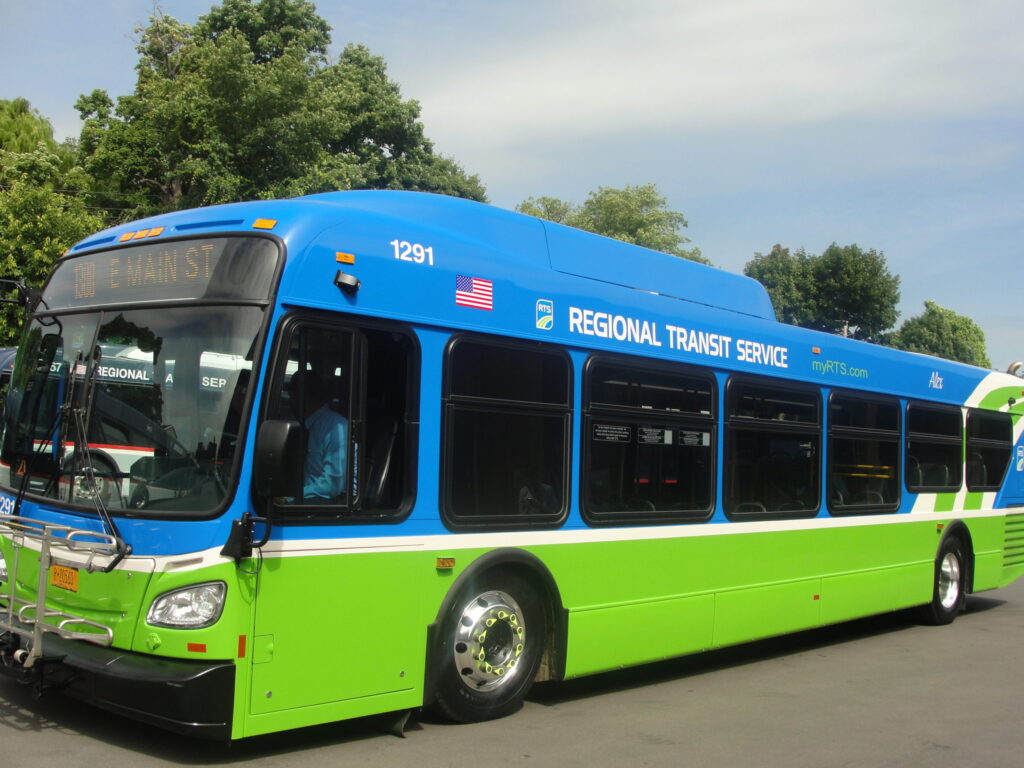 Blue and green RTS bus on city street