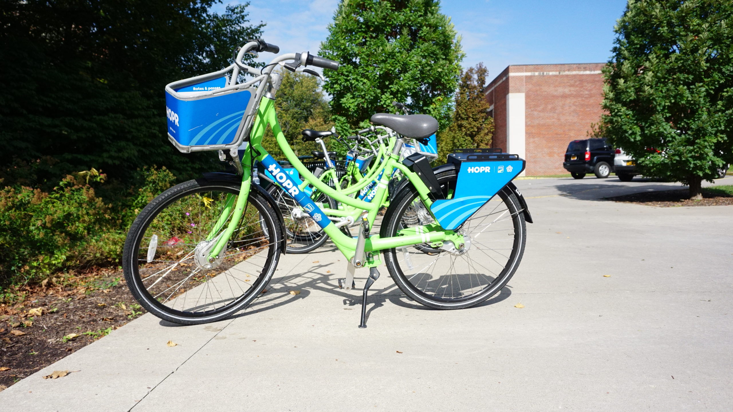 Green and blue HOPR bike parked on University of Rochester campus
