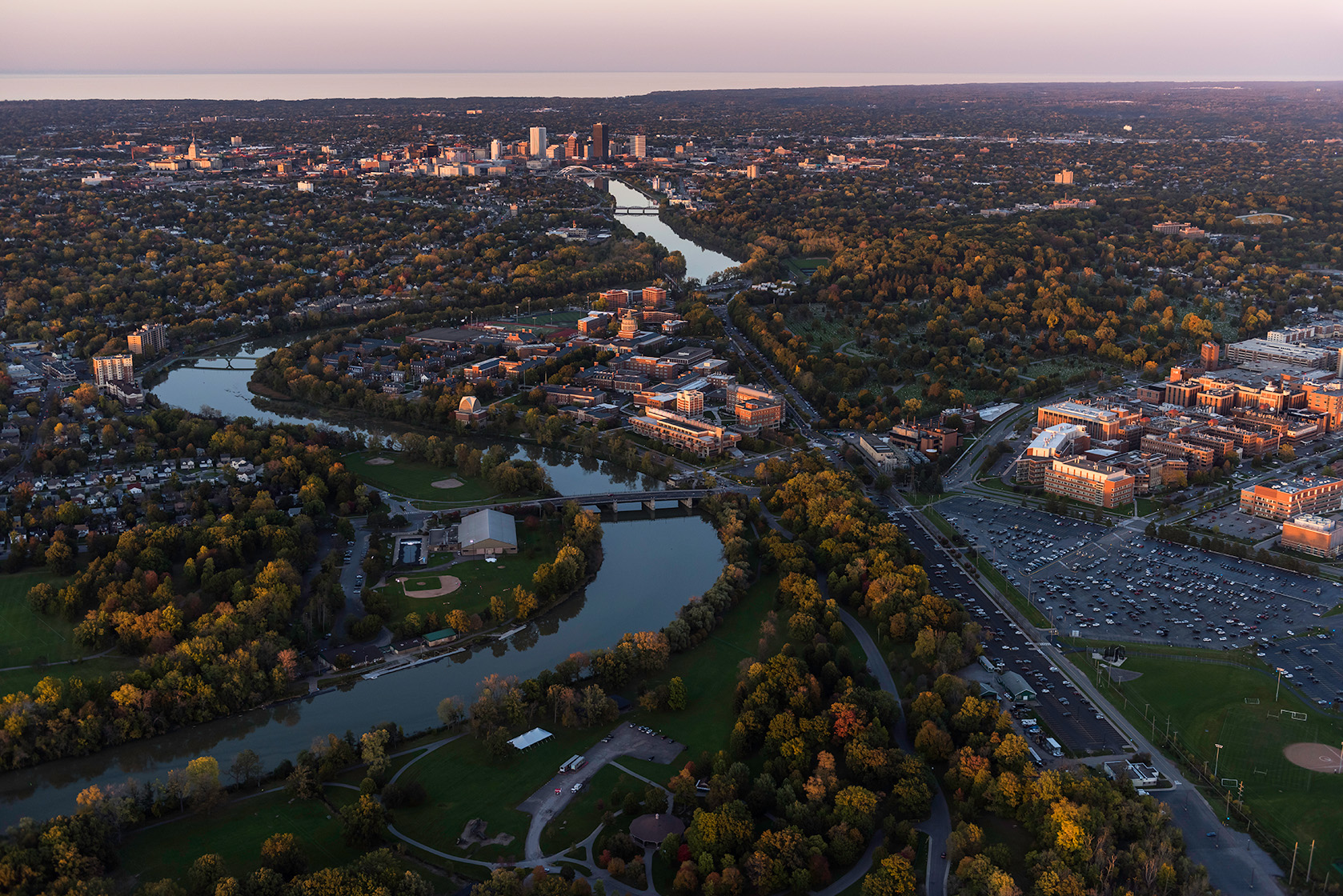 Aerial photo of University of Rochester's River Campus and Medical Center along with downtown Rochester, NY in in the evening.
