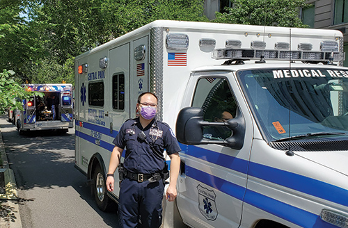 paramedic in a surgical mask outside an ambulance