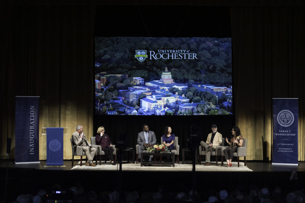A group of people on stage at a University of Rochester event, engaging with the audience and sharing insights.