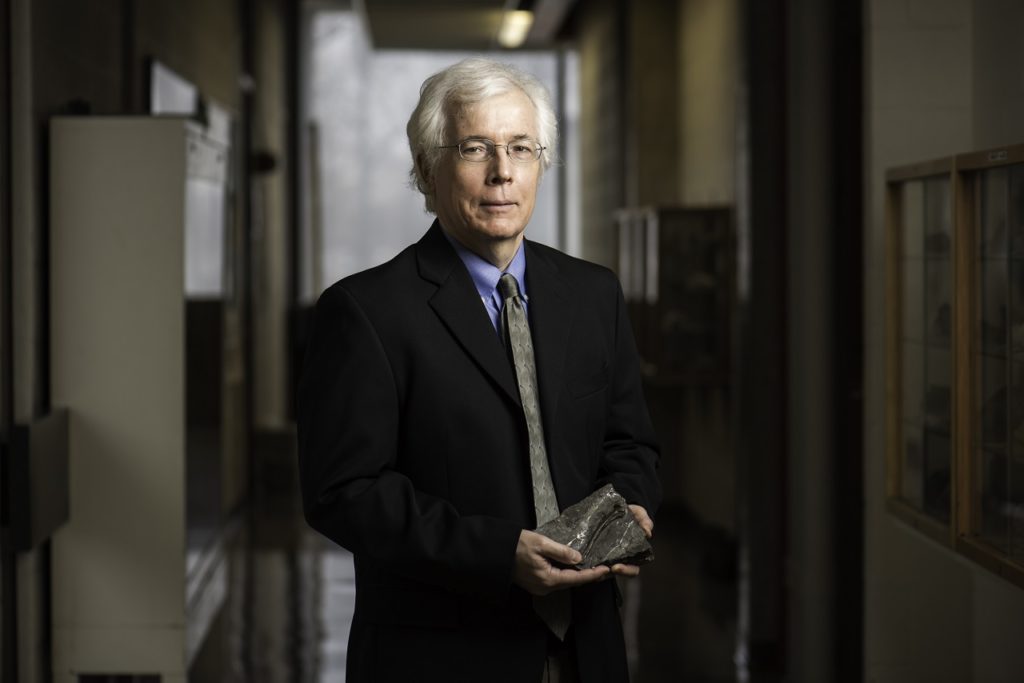 Professor John Tarduno holding a fossil as part of his research work