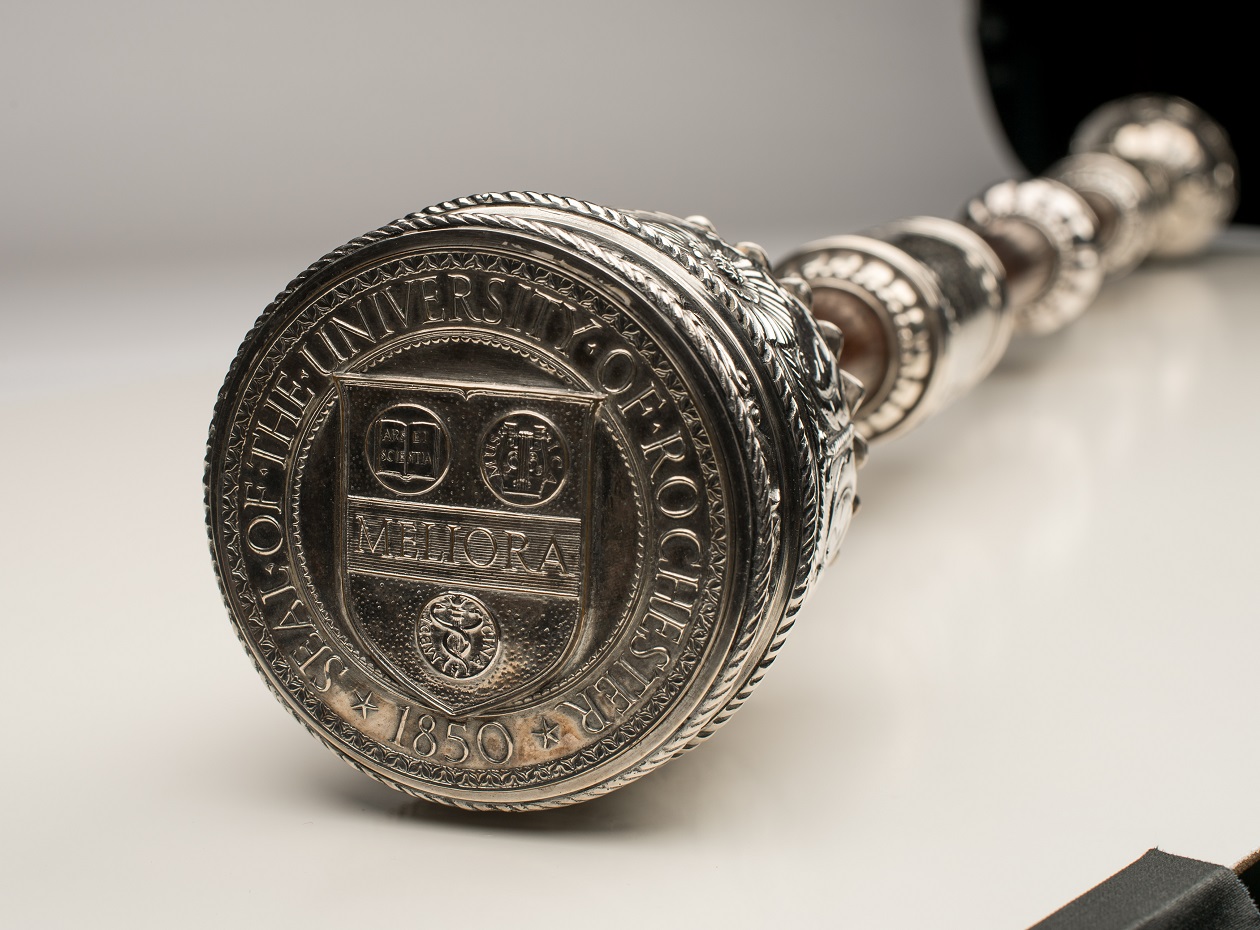 A University of Rochester mace and baton with the Meliora insignia