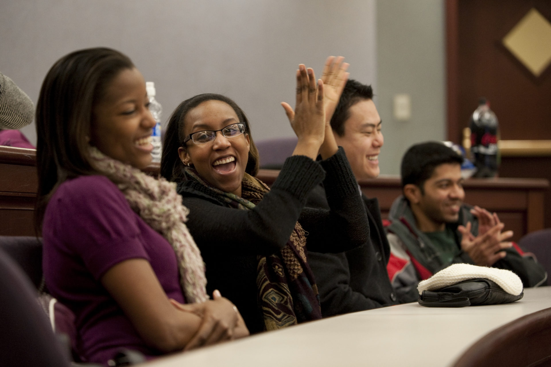 A group of University of Rochester students in a classroom, smiling and laughing