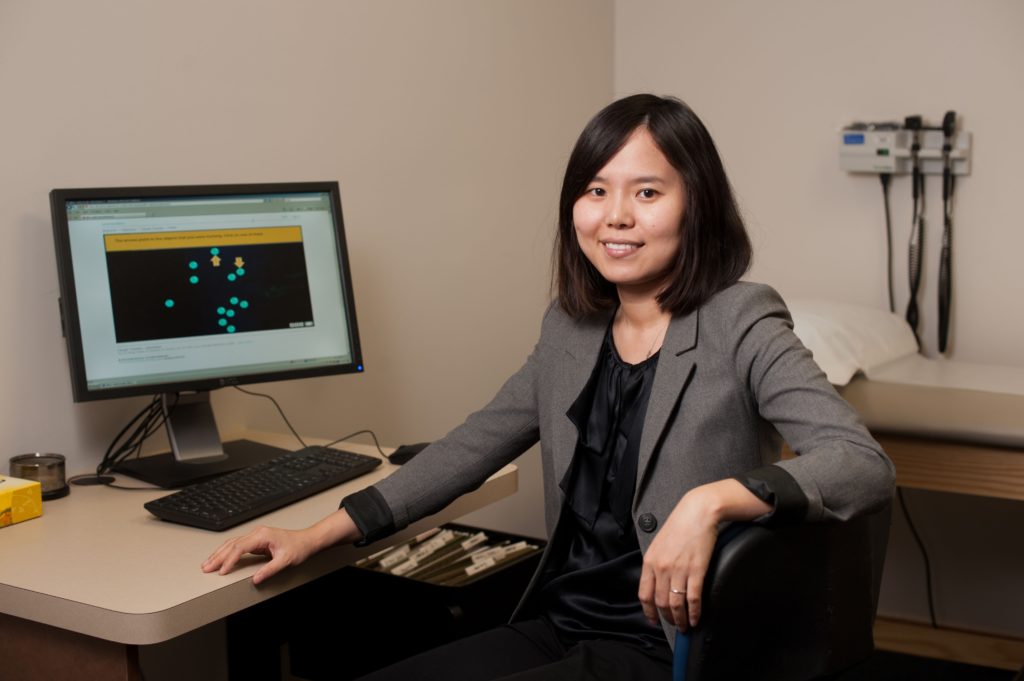 A University of Rochester researcher in front of a computer filled with data