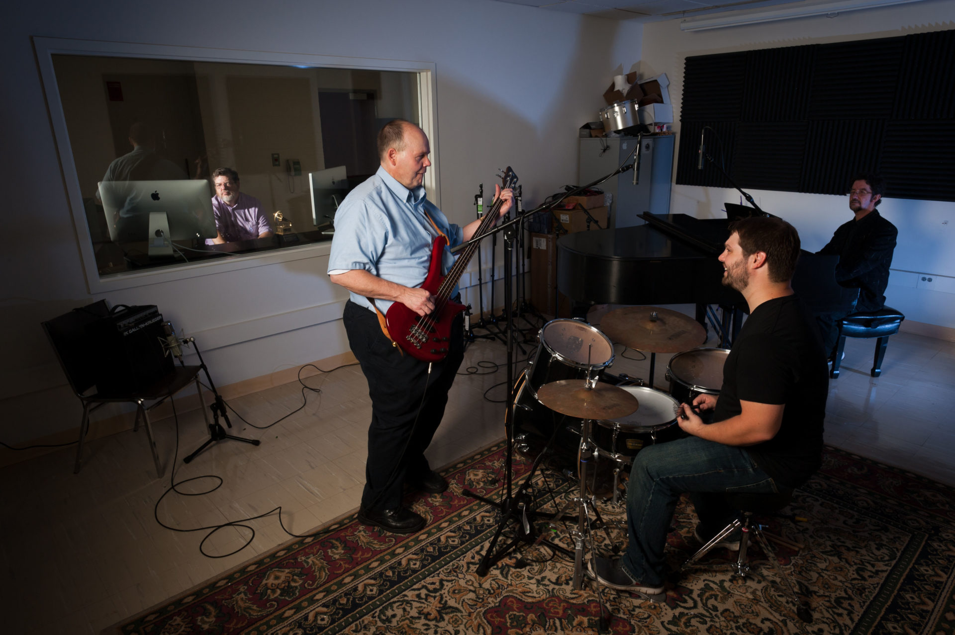 Professors Headlam and Bocko in a recording studio, playing a guitar and drum set