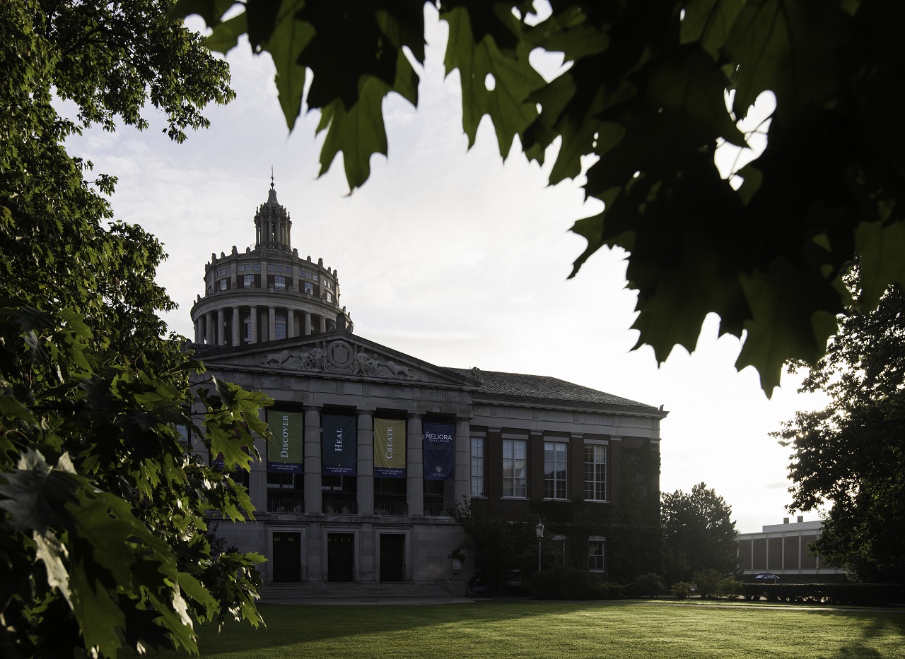 University of Rochester's Rush Rhees Library is pictured through the leaves of a tree