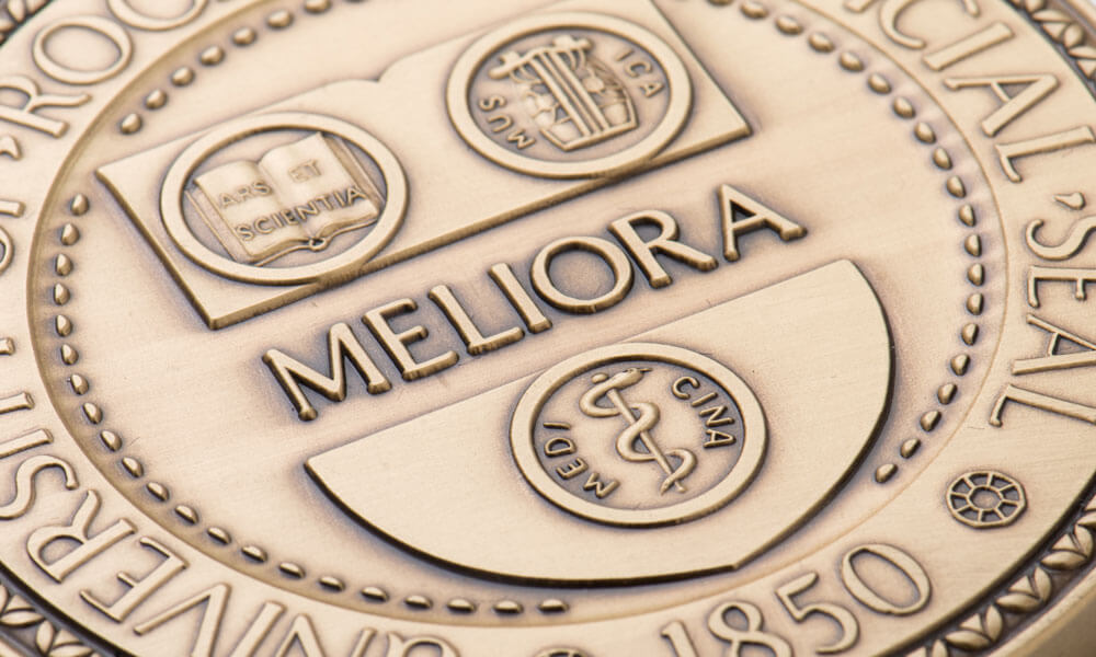 the Meliora insignia on a medal