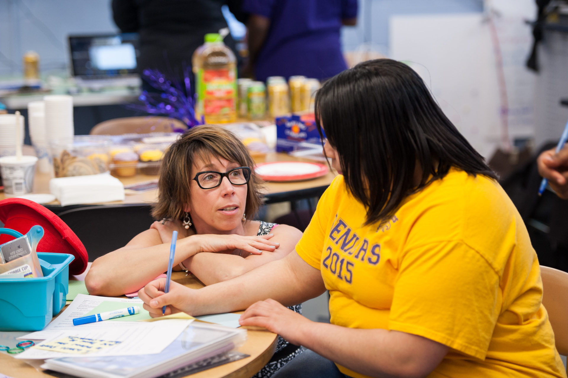 A Warner School teacher confers with a young student in a high school classroom