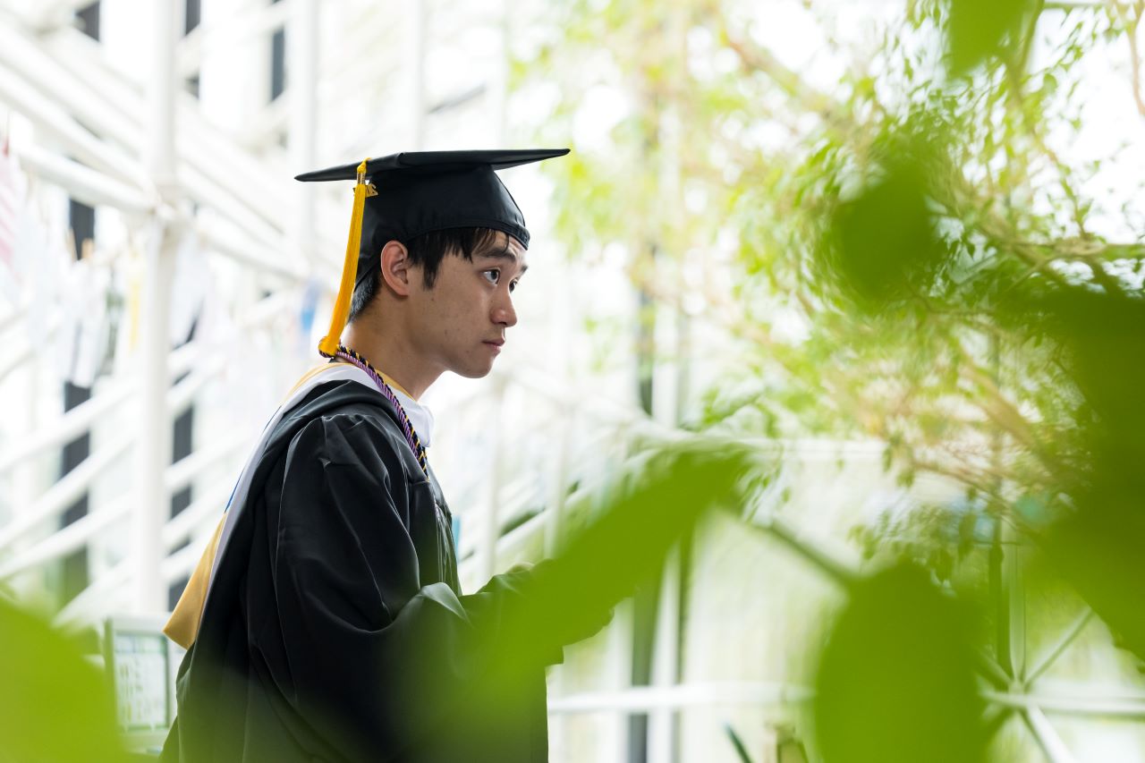 A University of Rochester student wearing regalia