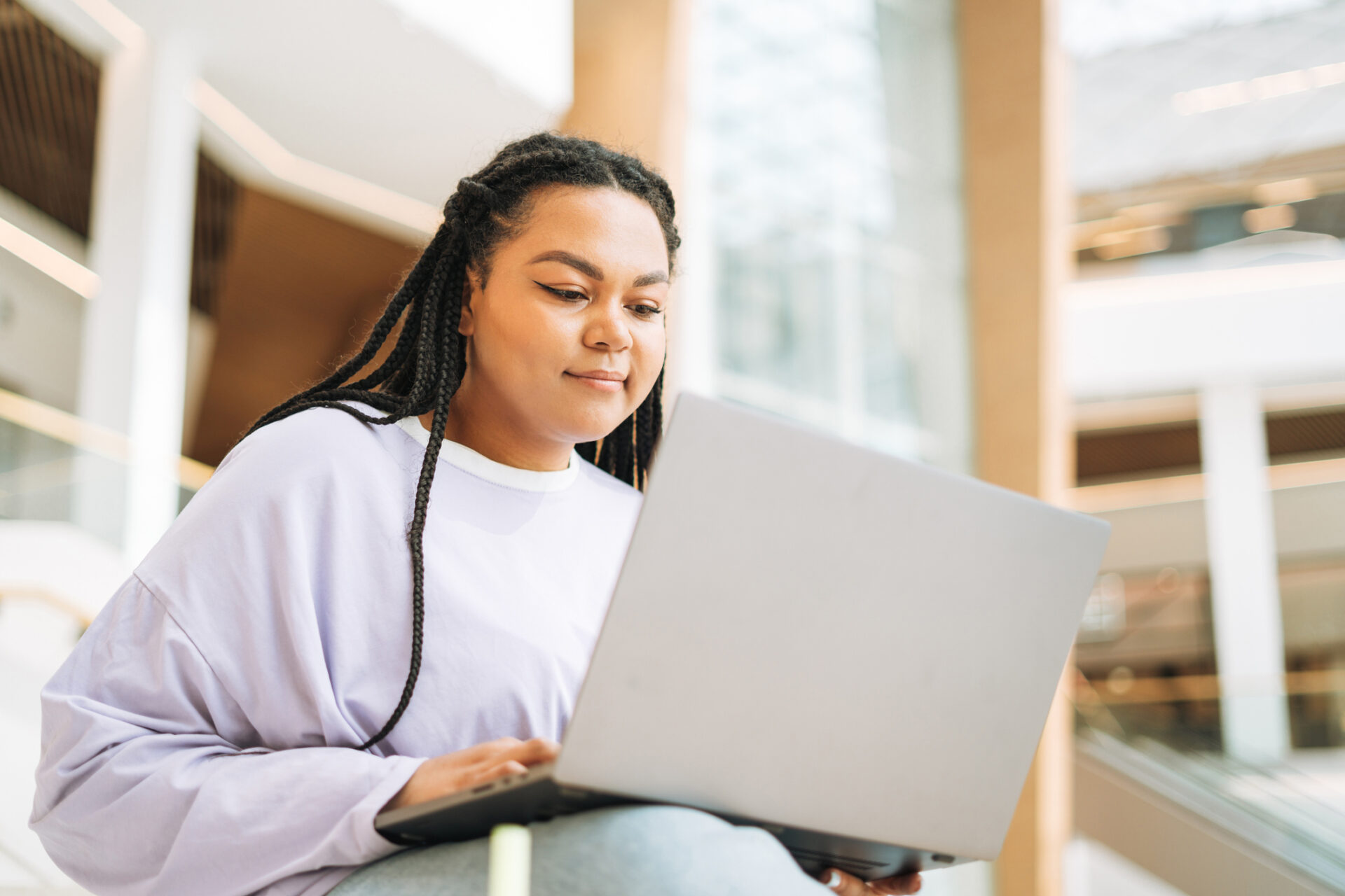 a student on her laptop outside of a building