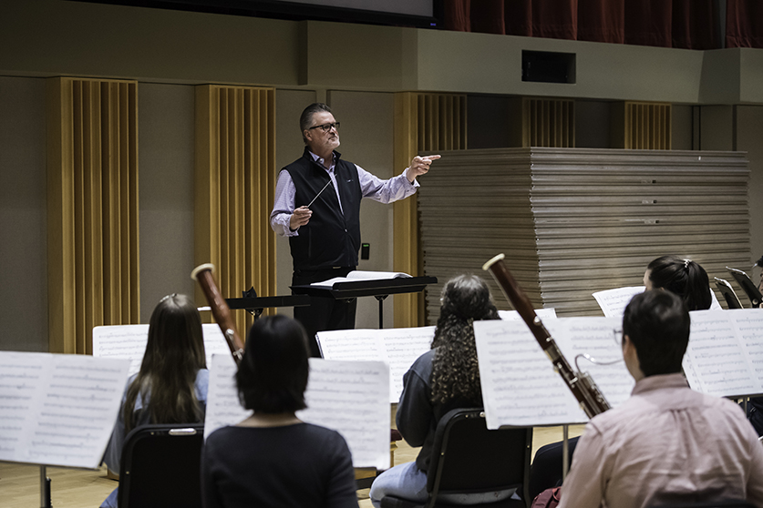 A professor conducting a lesson with the wind ensemble.