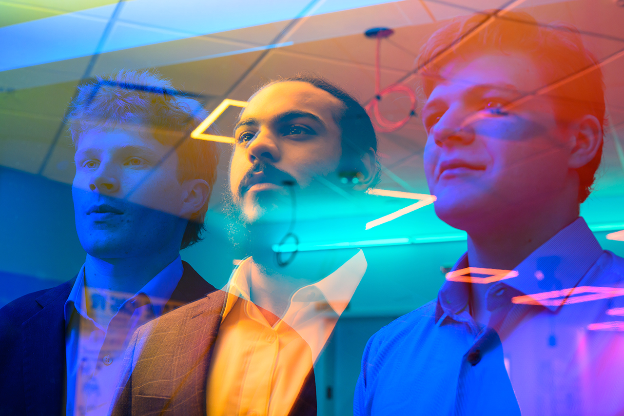 A colorful image of super imposed faces over a room in the background.