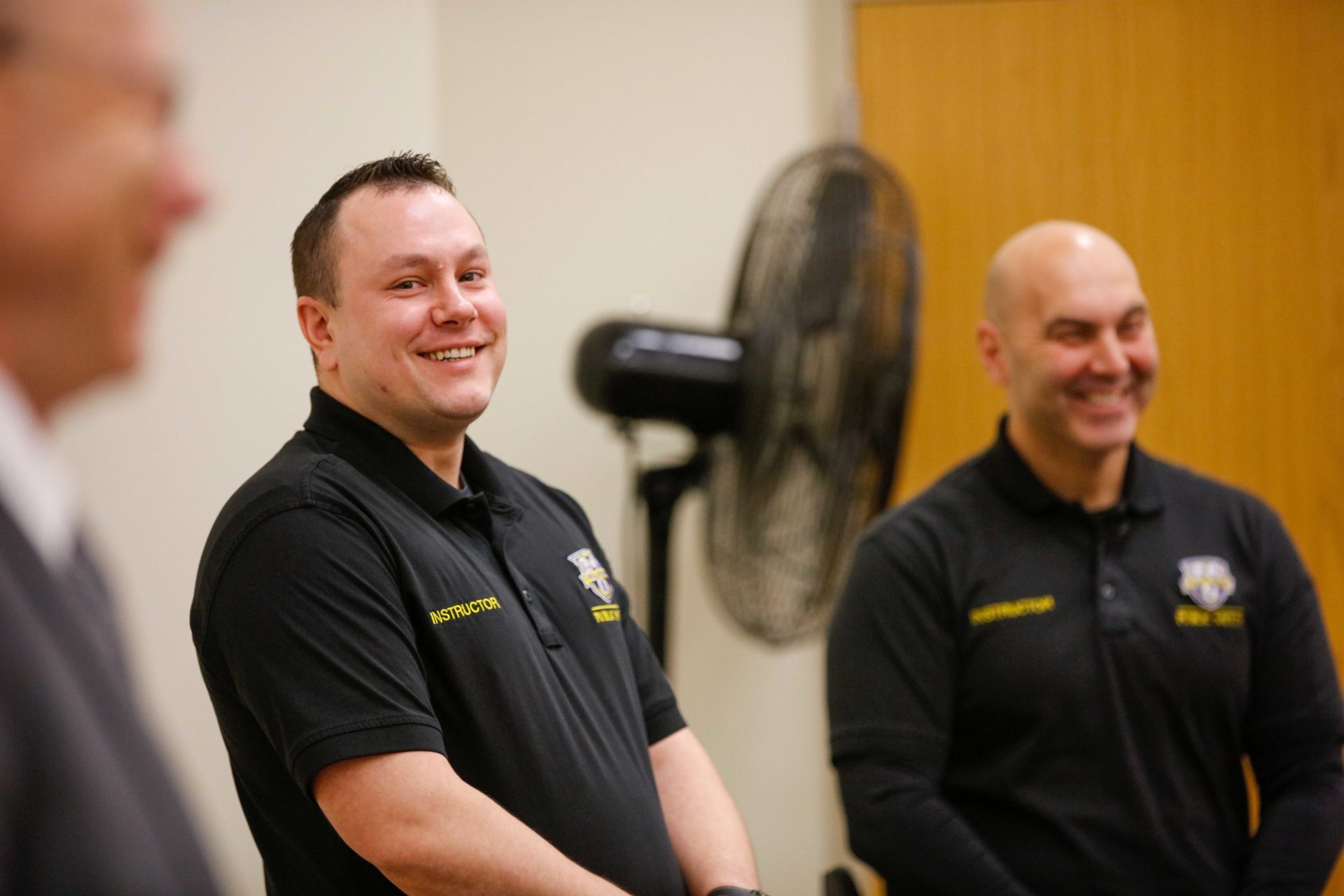 Two public safety officers smiling and speaking to a group