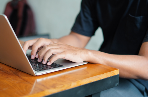 an image of a person typing on a laptop.