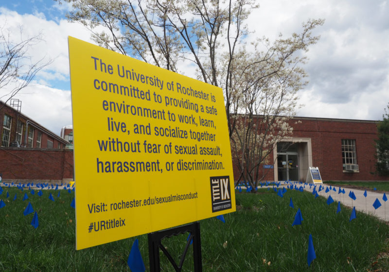A sign showing that the University is committed to providing an environment free from sexual harassment during the annual April flag display for Sexual Assault Awareness Month.