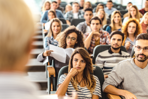 a photo of many people listening on as someone teaches.