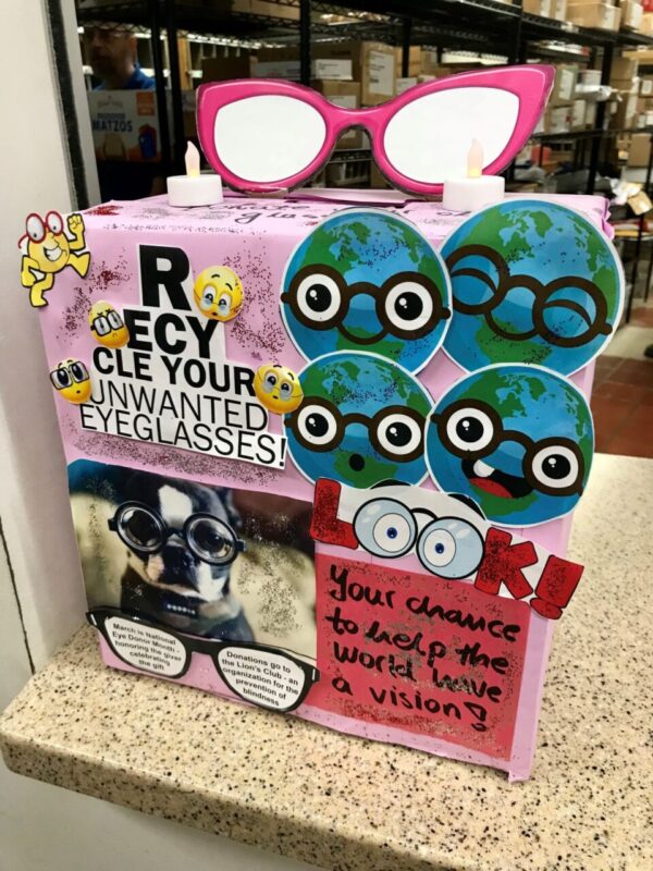 A decorated, homemade eyeglasses recycling collection box that says "Recycle your unwanted eyeglasses!"