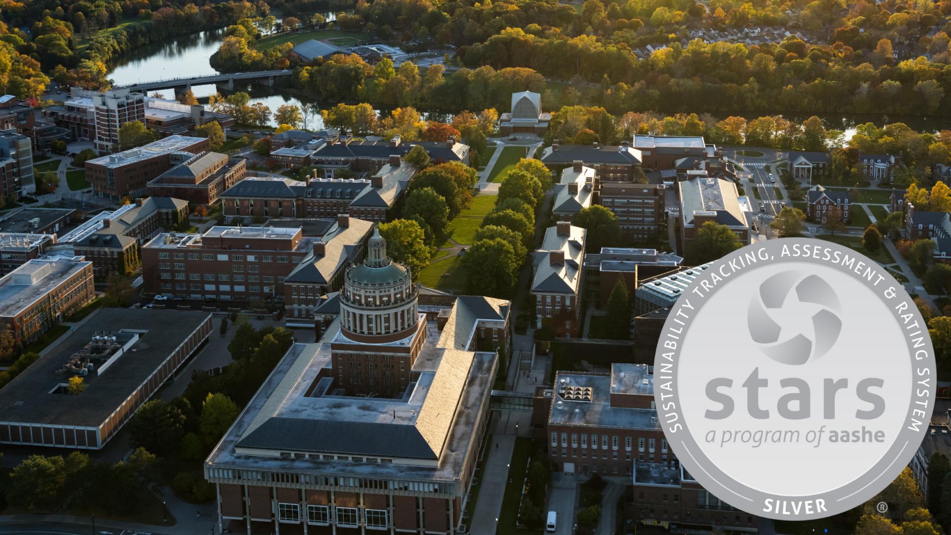 Aerial view of the University of Rochester River campus looking from Rush Rhees towards the Genesee River. An image of the STARS Silver metal is overlayed on top of the photo.