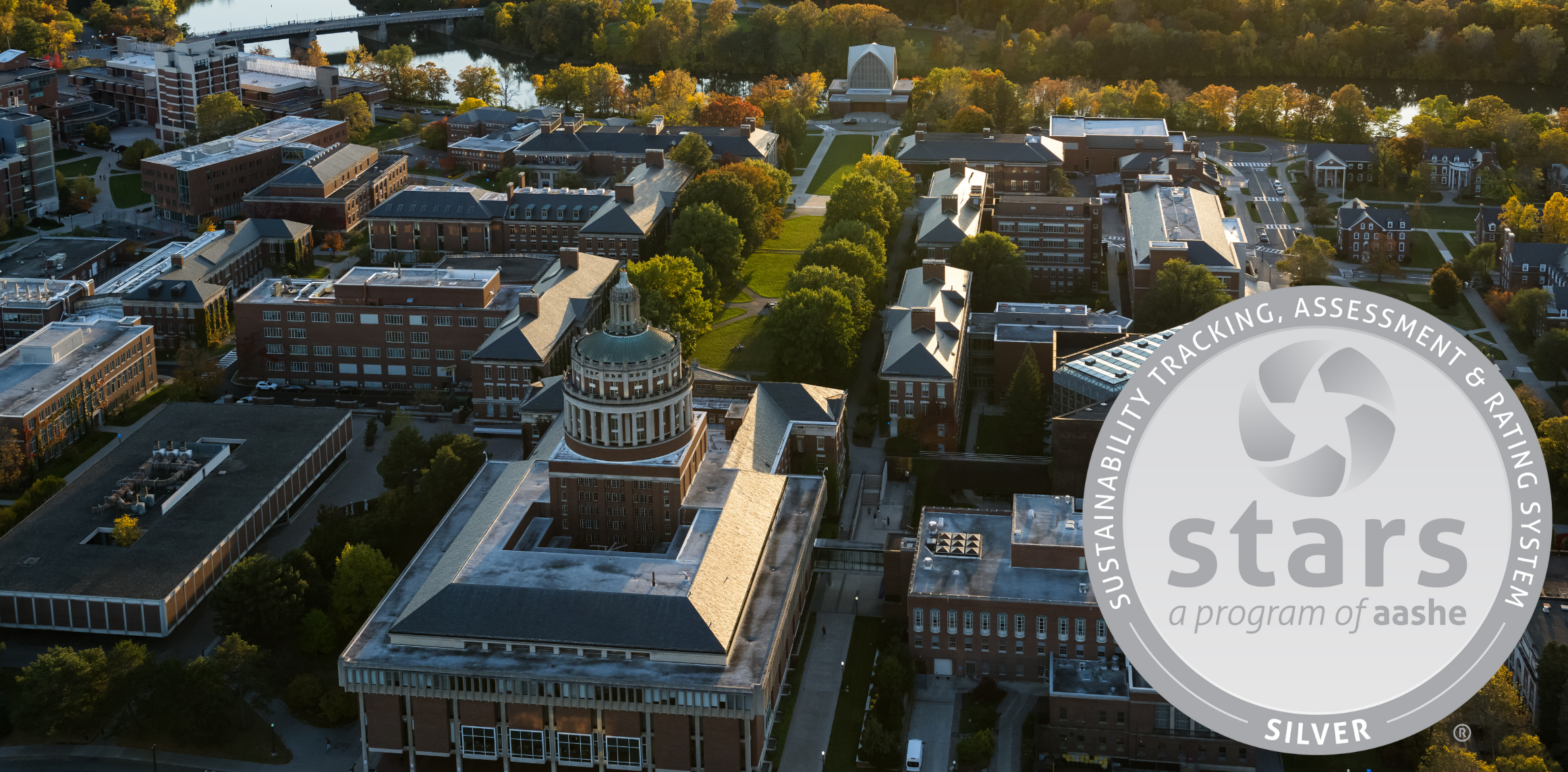 Aerial view of the University of Rochester River campus looking from Rush Rhees towards the Genesee River. An image of the STARS Silver metal is overlayed on top of the photo.