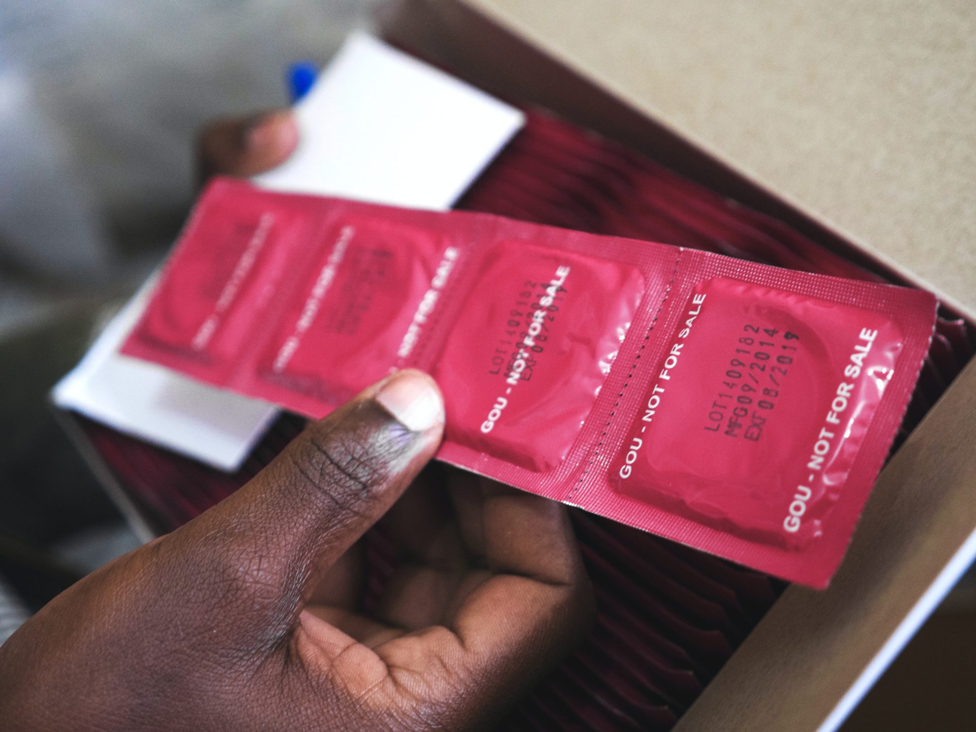 A person's hand holding condoms