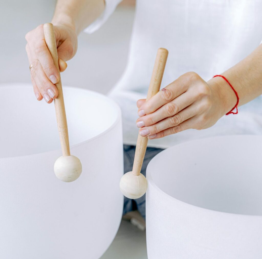 Close up of a person using a meditation sound bowl.