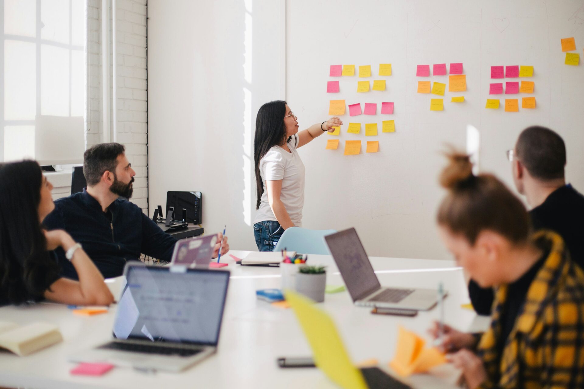 Woman giving a presentation in a small meeting room.