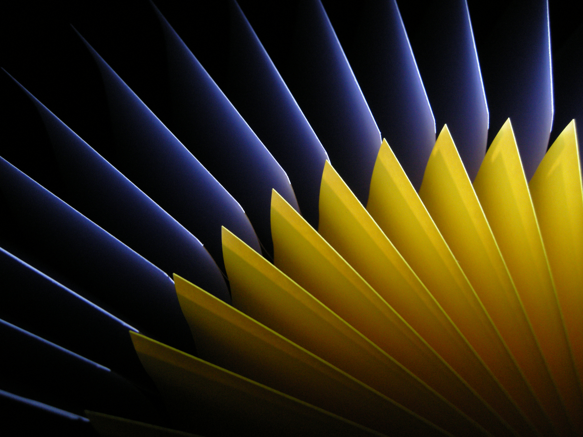 Abstract radial pattern of yellow and blue papers using light and shadow.