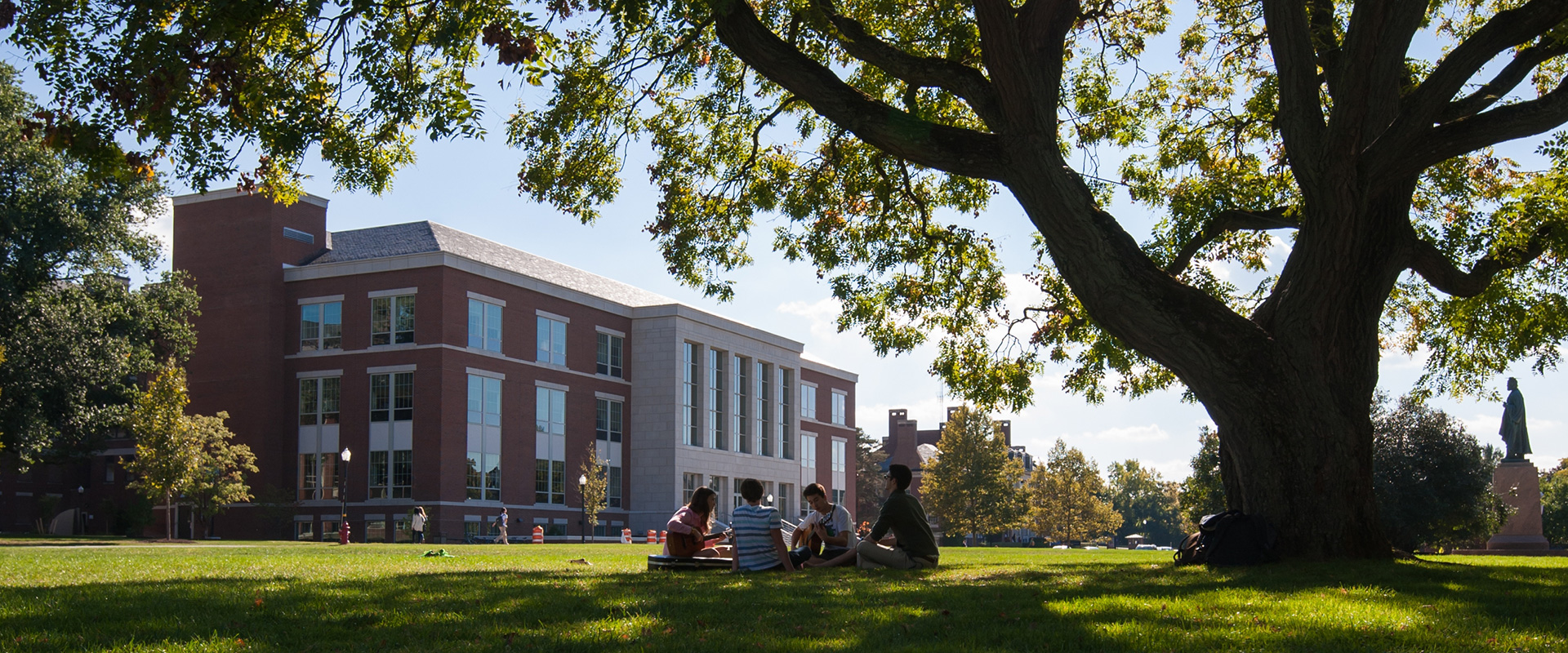 exterior of LeChase hall with students sitting on the grass